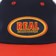 Real Oval Emb Strapback Hat - navy/red/yellow - front detail